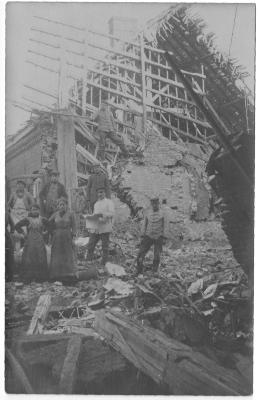 Mensen poseren bij huis in puin na bombardement