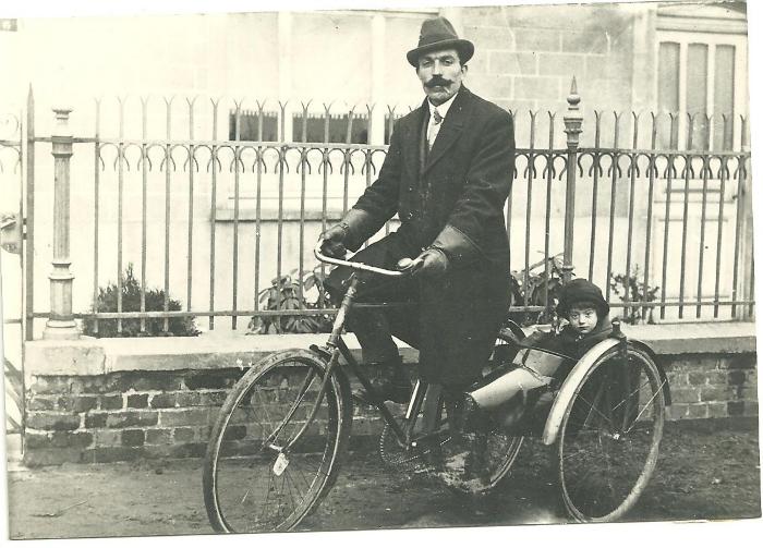 Médart Beernaert op een driewieler fiets met kleindochter Clara in zijspan , Gits, 1920