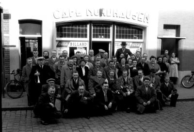 Groepsfoto voor café Nordhausen, man met weekbode, Izegem 1957