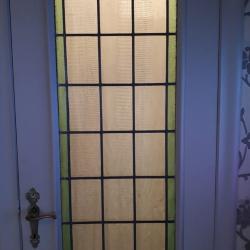 Rechthoekig glasraam met groene kader in deur
