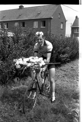 Wielrenner Carlos Vandecappele poseert met fiets en bloemen, Izegem 1957