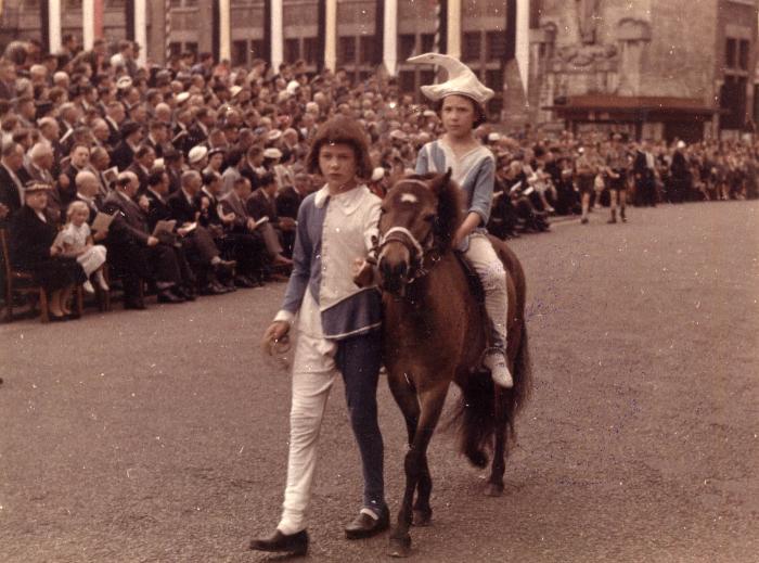 Kind begeleidt een pony met daarop een kind tijdens de Rodenbachstoet