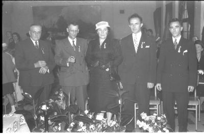 Huldiging gedecoreerden Unions: enkele gedecoreerden poseren in zaal, Izegem 1957