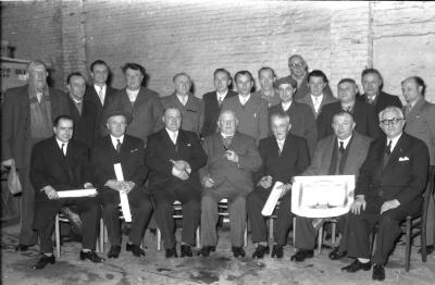 Kampioenviering Duivenmelkers café 'St.-Pieter': groepsfoto met kampioen Robert Maes, Izegem 1957