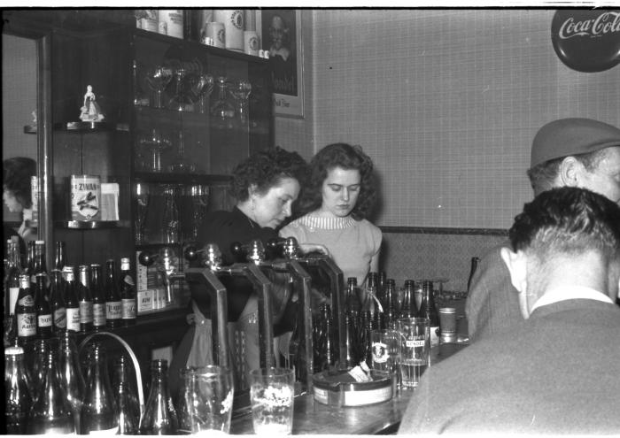 Fietsen op rollen: Annie met vrouw achter toog, Izegem 1958