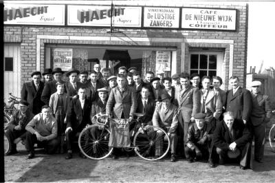 Café 'De Nieuwe Wijk, L. Langsweirt, Coiffeur': groepsfoto, Emelgem 1958