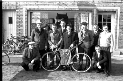 Café 'De Nieuwe Wijk, L. Langsweirt, Coiffeur': Houthoofd poseert met bestuur, Emelgem 1958