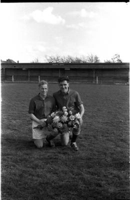 Voetbalclub Dentergem is kampioen: 2 spelers poseren met bloemen, 1958